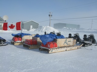 Snowmobiles and sleds (komatiks) with traveling gear used by the Canadian Army Rangers for cold weather patrols.