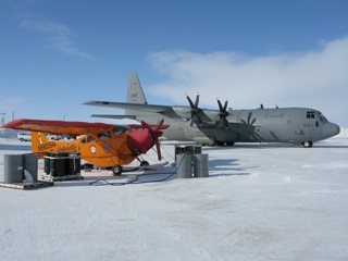 Refueling the Polar Pumpkin from steel barrels immediately adjacent to a Canadian Forces Hercules C-130J.