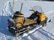 My traveling snowmobile - with snowshoes, scoop shovel, and axe on board.  A rifle and matches - with birch bark fire kindling - are other important survival items.
