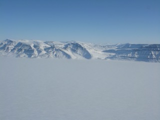 Scenes across Eureka Sound to Ellesmere Island and Axel Heiberg island.  Note the folded geology. Fossils, petrified wood, and coal are found in the region.