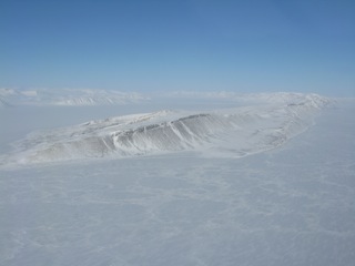 Scenes across Eureka Sound to Ellesmere Island and Axel Heiberg island.  Note the folded geology. Fossils, petrified wood, and coal are found in the region.