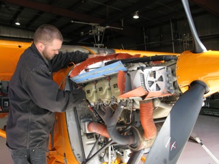 Expert mechanic, at Dakota Helicopters, Bo Klindworth doing an oil change and inspection on the Polar Pumpkin.